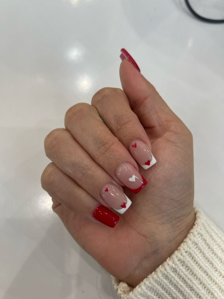 Chic Red and Nude Nail Design with Heart Motifs and French Tips for Romantic Elegance.