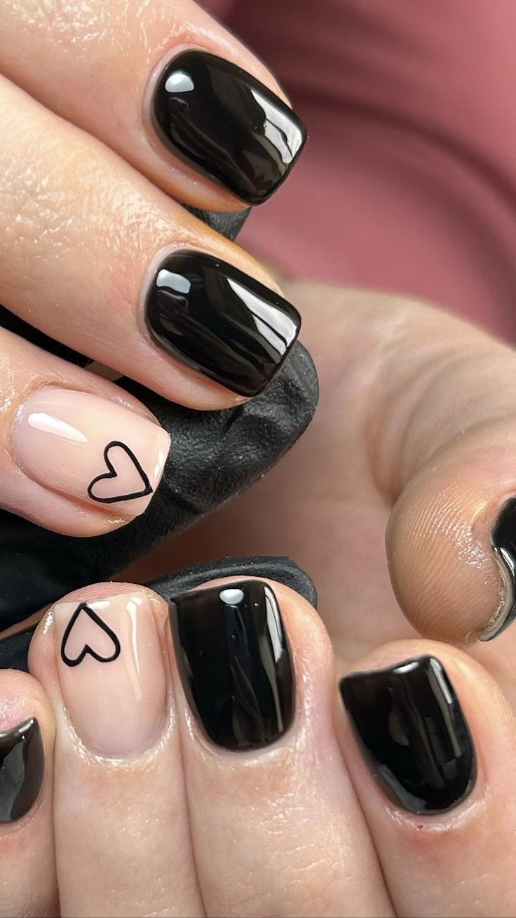 Chic Black and Nude Nail Design with Playful Heart Accents.