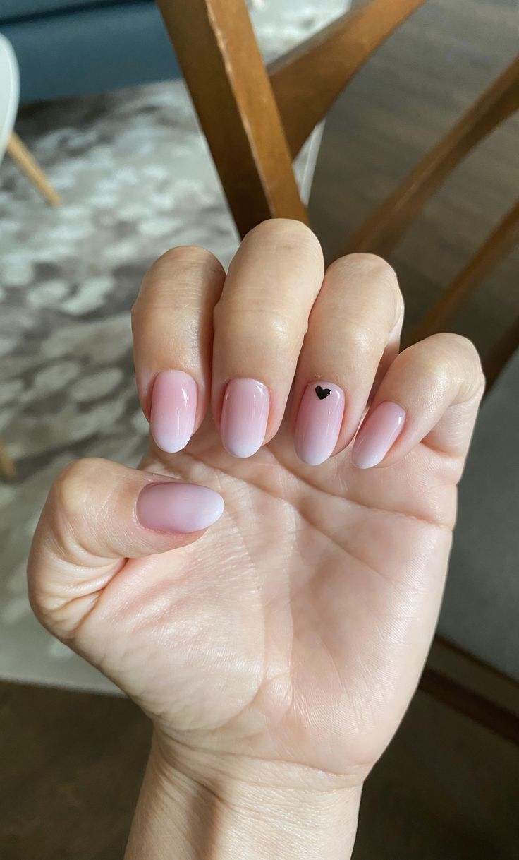 Chic Soft Ombre Pink Nails with Playful Black Heart Accent