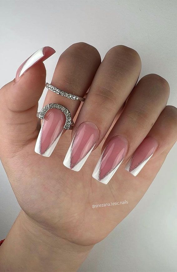 Chic Nail Design: Soft Pink Base with Bold White Tips and Silver Accents.