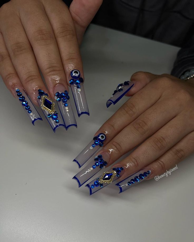 Elegant Blue-Themed Nail Design with Clear Tips and Glamorous Embellishments.