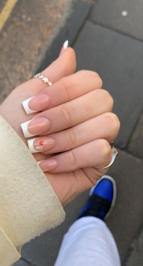 Chic French Manicure with a Modern Twist and Playful Heart Accent.