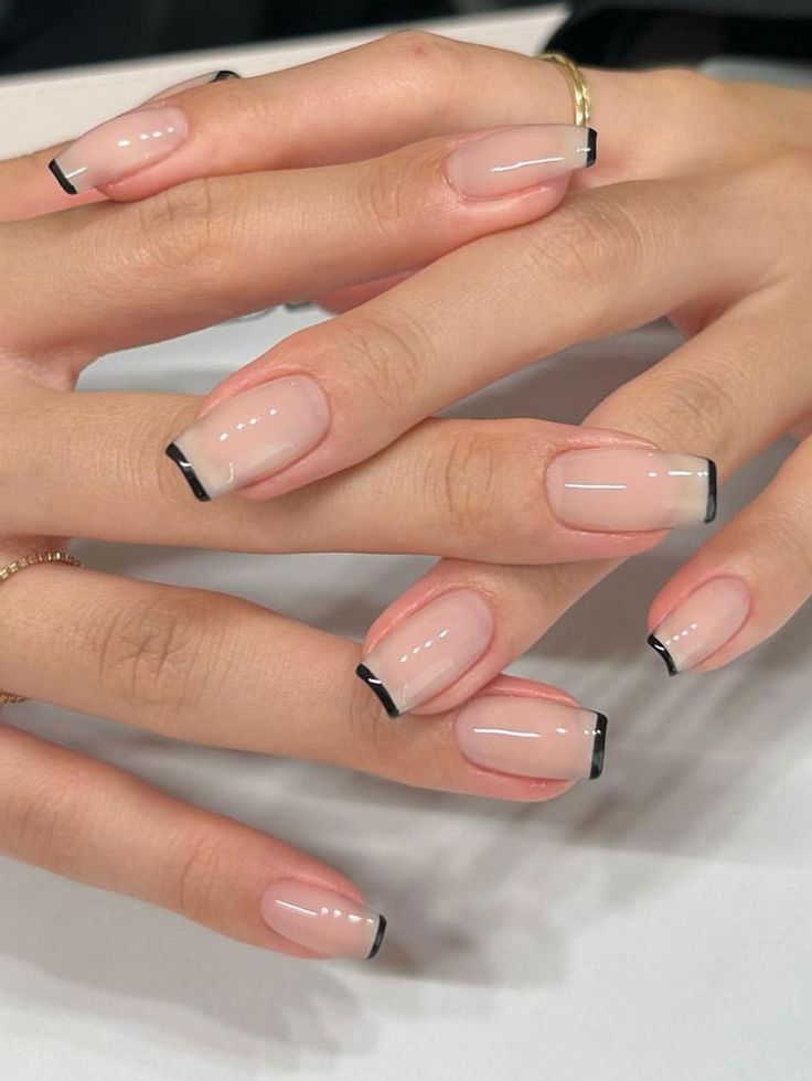 Sophisticated Modern French Manicure: Soft Nude Base with Delicate Black Tips.