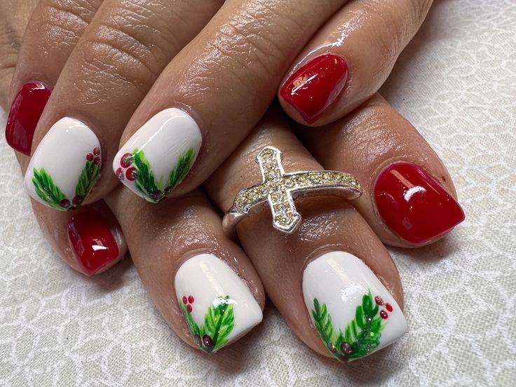 Festive Red and White Nail Design with Green Foliage and Berry Accents.