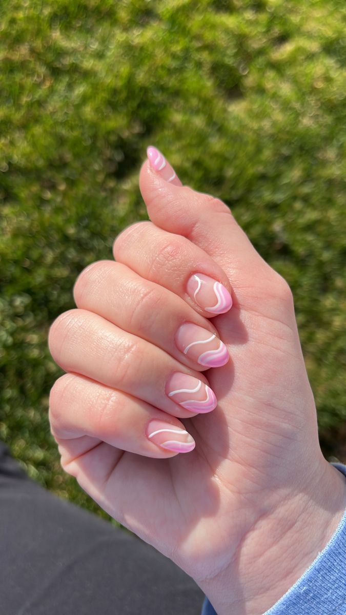 Elegant Pink Nail Design with Swirling White Accents for a Fresh Spring/Summer Look.