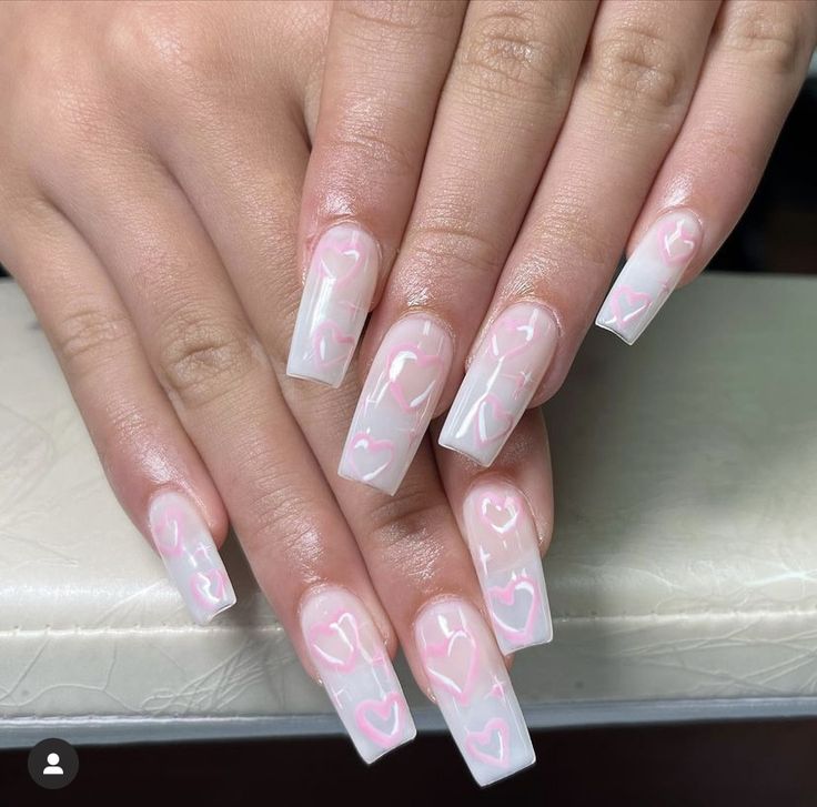 Romantic Chic: Elegant Clear and Soft Pink Nail Design with Playful Heart Accents.