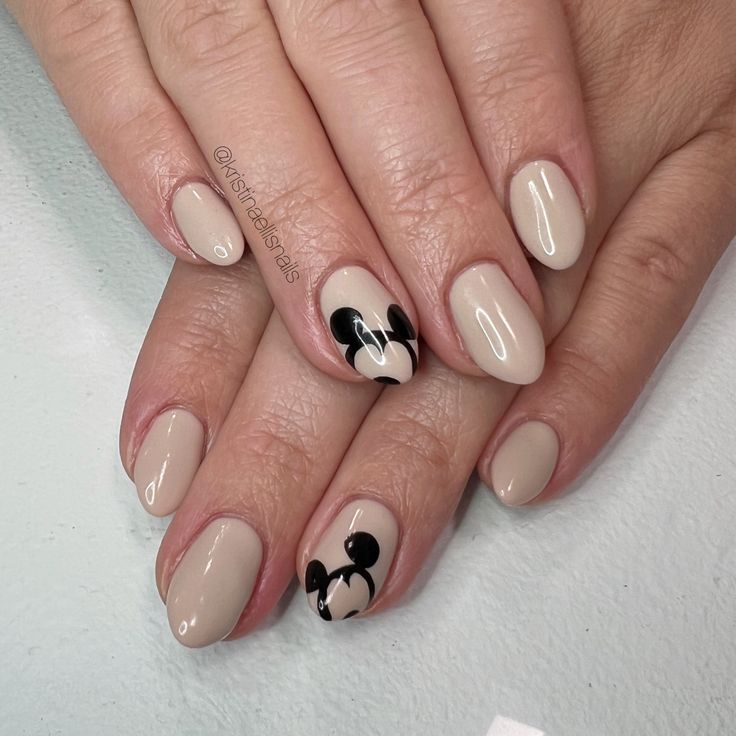 Chic Nude Nail Design with Whimsical Black Accents and Iconic Character Motifs.