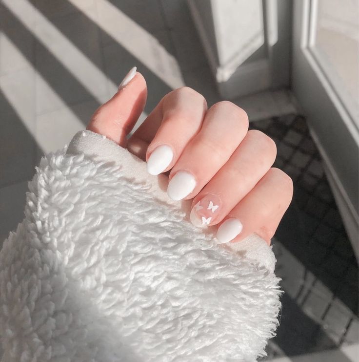 Elegant White Matte Nails with Playful Butterfly Accents: A Versatile Design for Any Occasion.