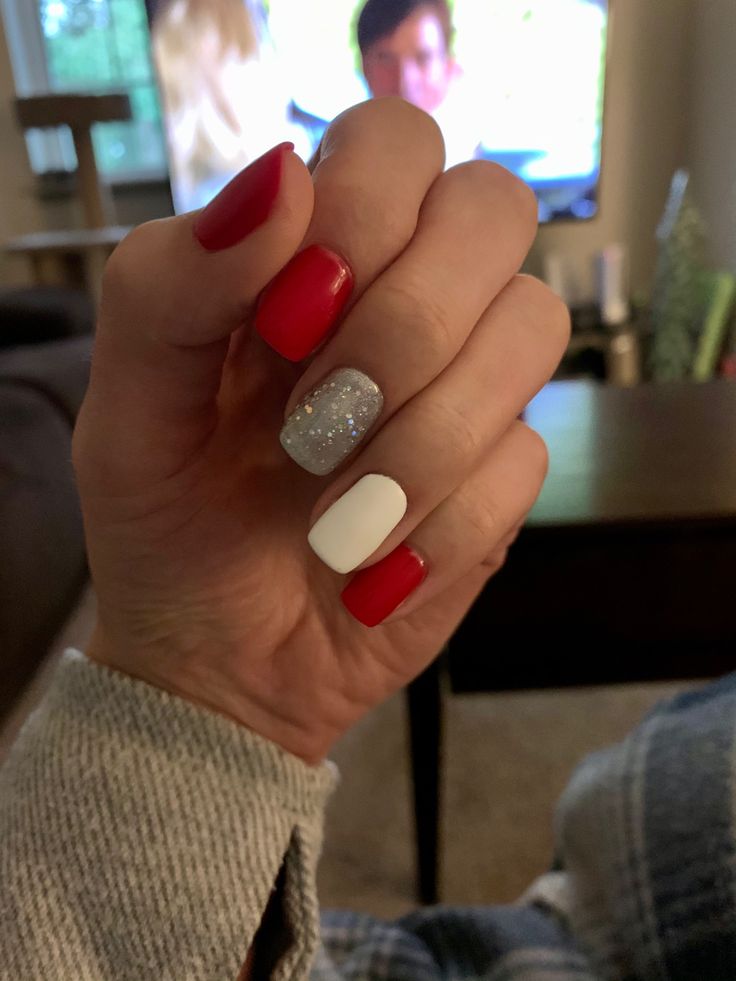 Bold and Elegant: A Striking Nail Design of Deep Red, Pristine White, and Glittery Silver.