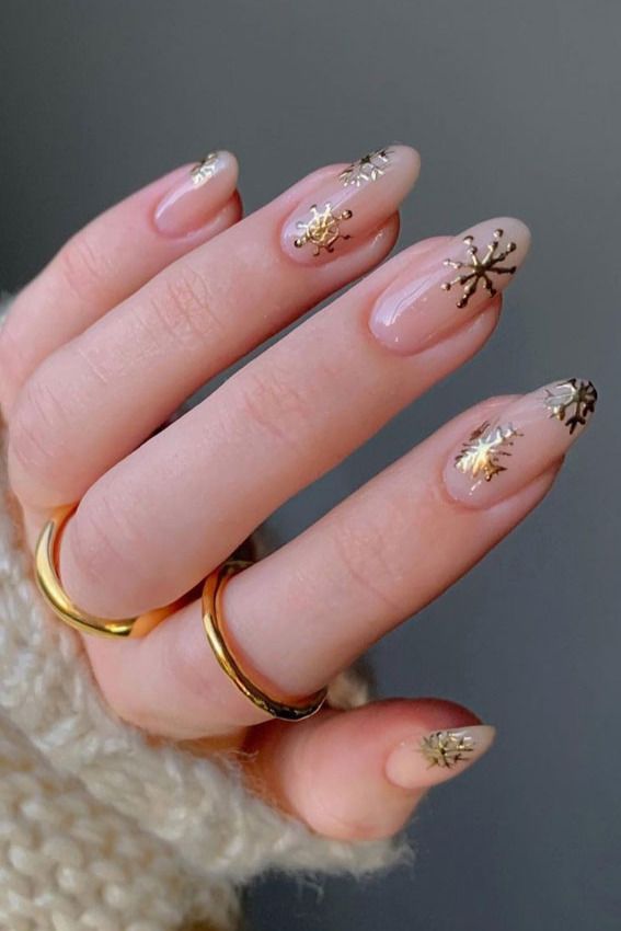 Elegant Winter Nail Design: Soft Nude Base with Golden Snowflake Accents