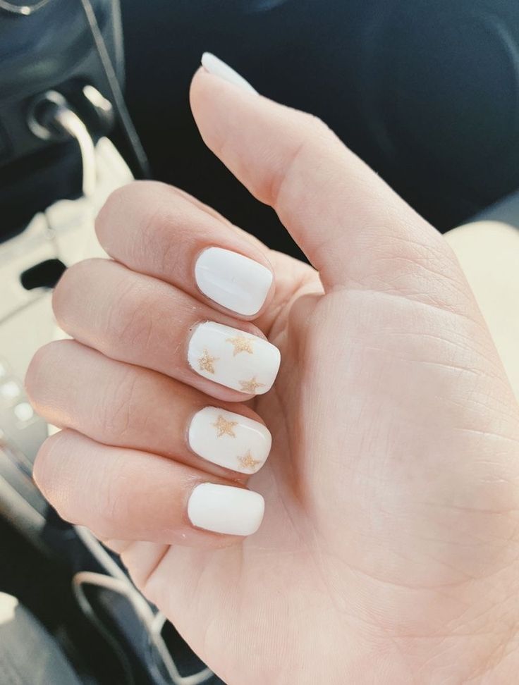 Elegant Chic White Nail Design with Glossy Finish and Gold Star Accents