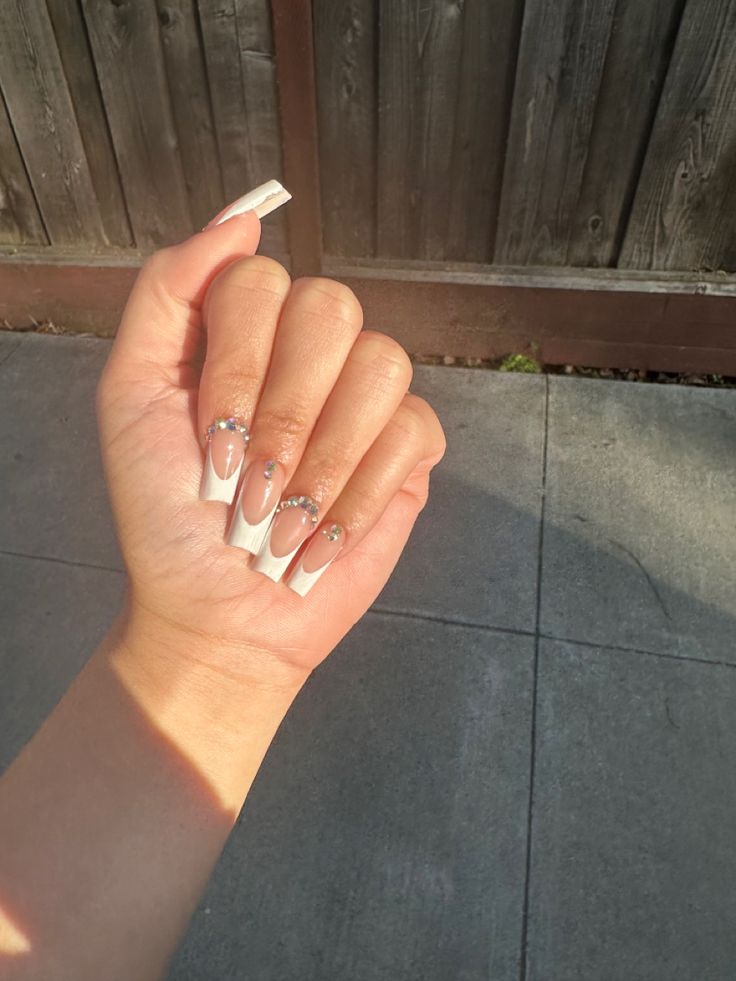 Sophisticated Long Clear Tips with White French Manicure and Rhinestone Embellishments.