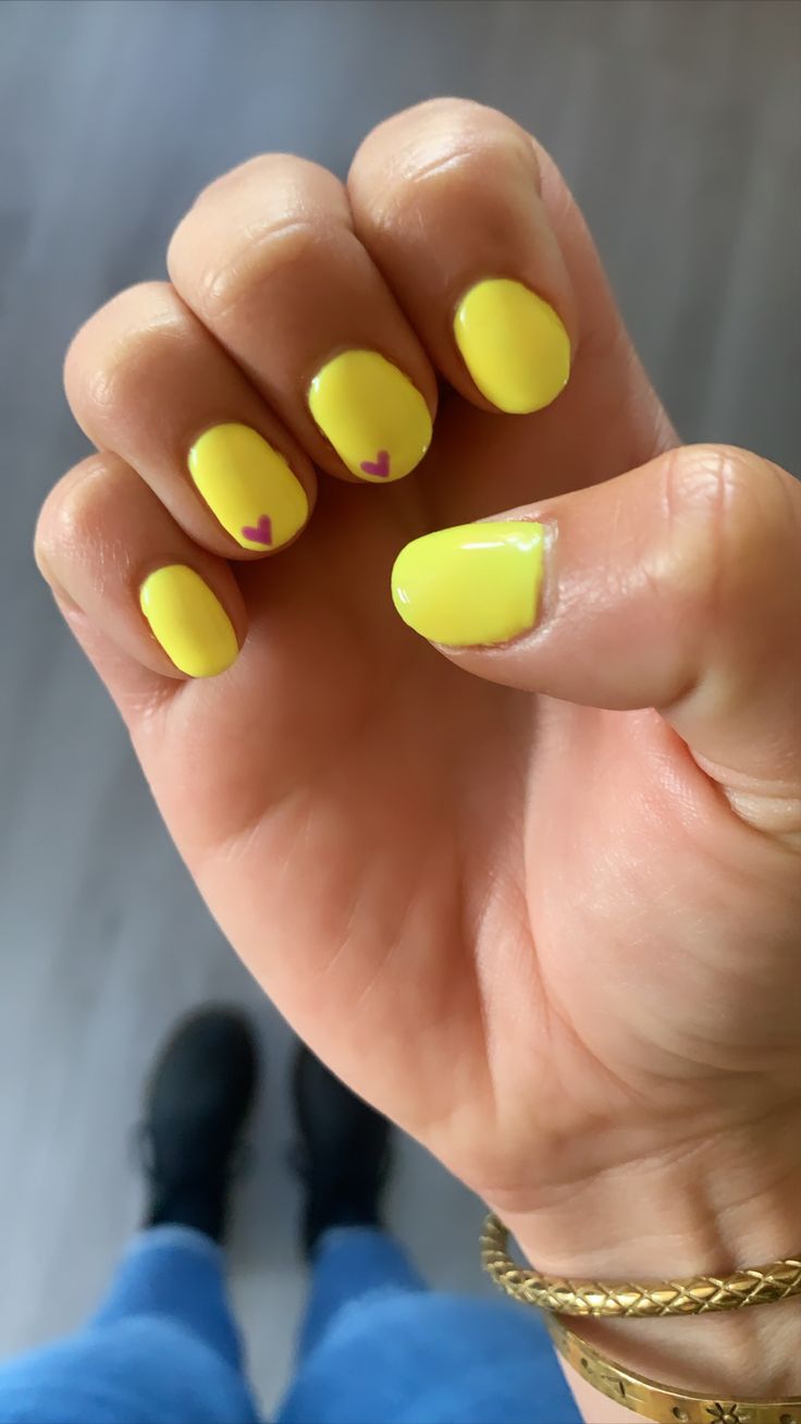 Cheerful Yellow Nail Design with Whimsical Heart Accents