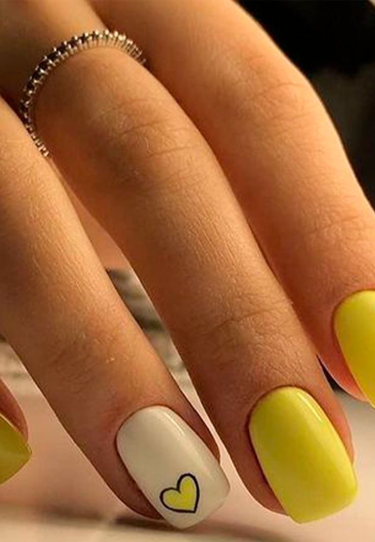 Cheerful Vibrant Yellow Nail Design with Playful Heart Detailing and Glossy Finish.