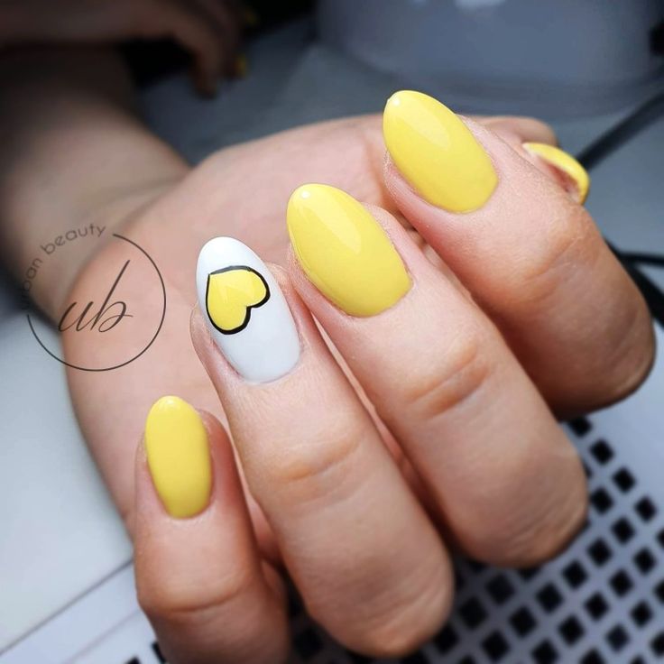 Vibrant Yellow Manicure with Glossy Finish and Playful White Heart Accent.