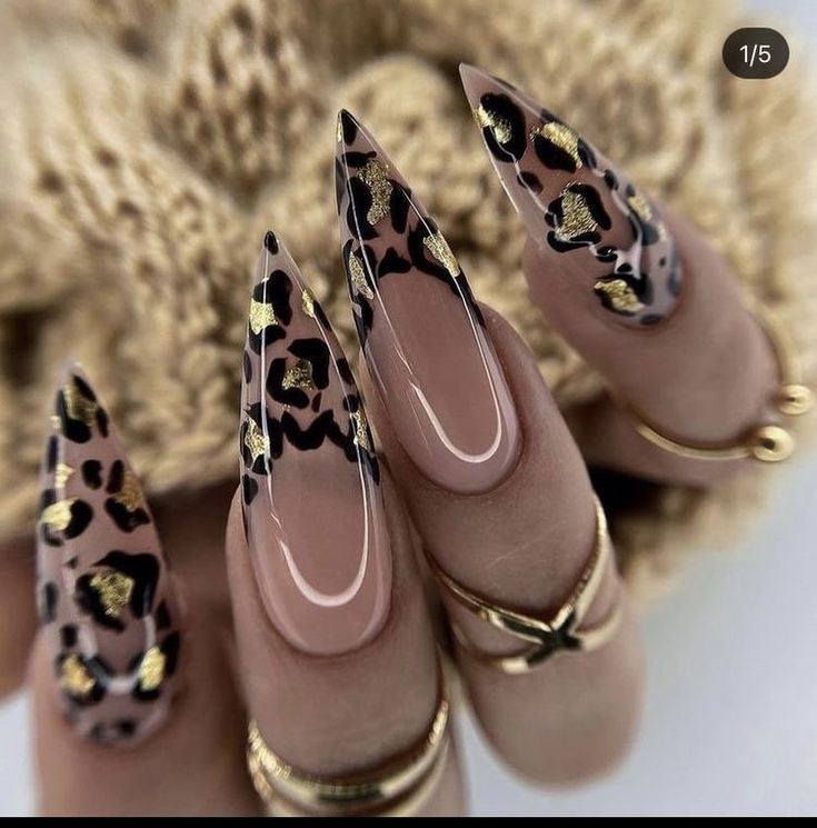 Elegant Stiletto Leopard Print Nails with Bold Black and Gold Accents.