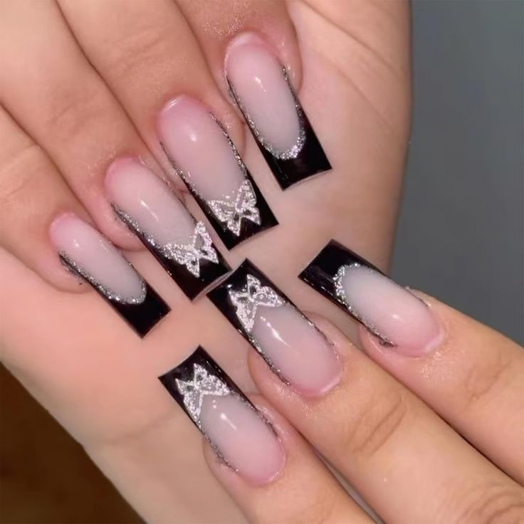 Bold Black and Clear Ombre Nails with Elegant Silver Butterfly Accents.