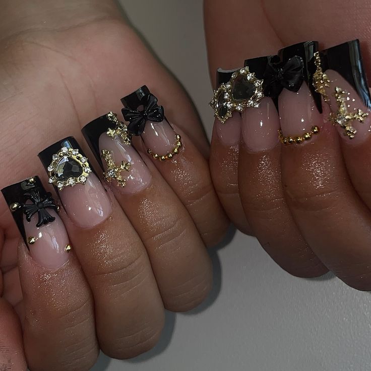 Luxurious Black and Nude Nail Design with Intricate Embellishments for Special Occasions.