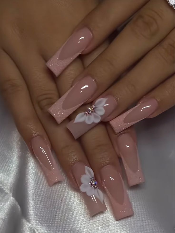 Sophisticated Soft Pink Nail Design with Glossy Finishes and Floral Rhinestone Accents.