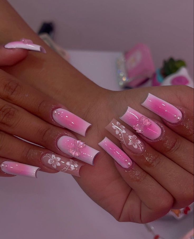 Elegant Gradient Pink Nail Design with Floral Accents for a Sophisticated Look.