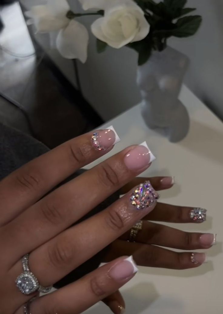 Chic Nude and White Tip Nail Design with Sparkling Rhinestones for a Sophisticated Touch.