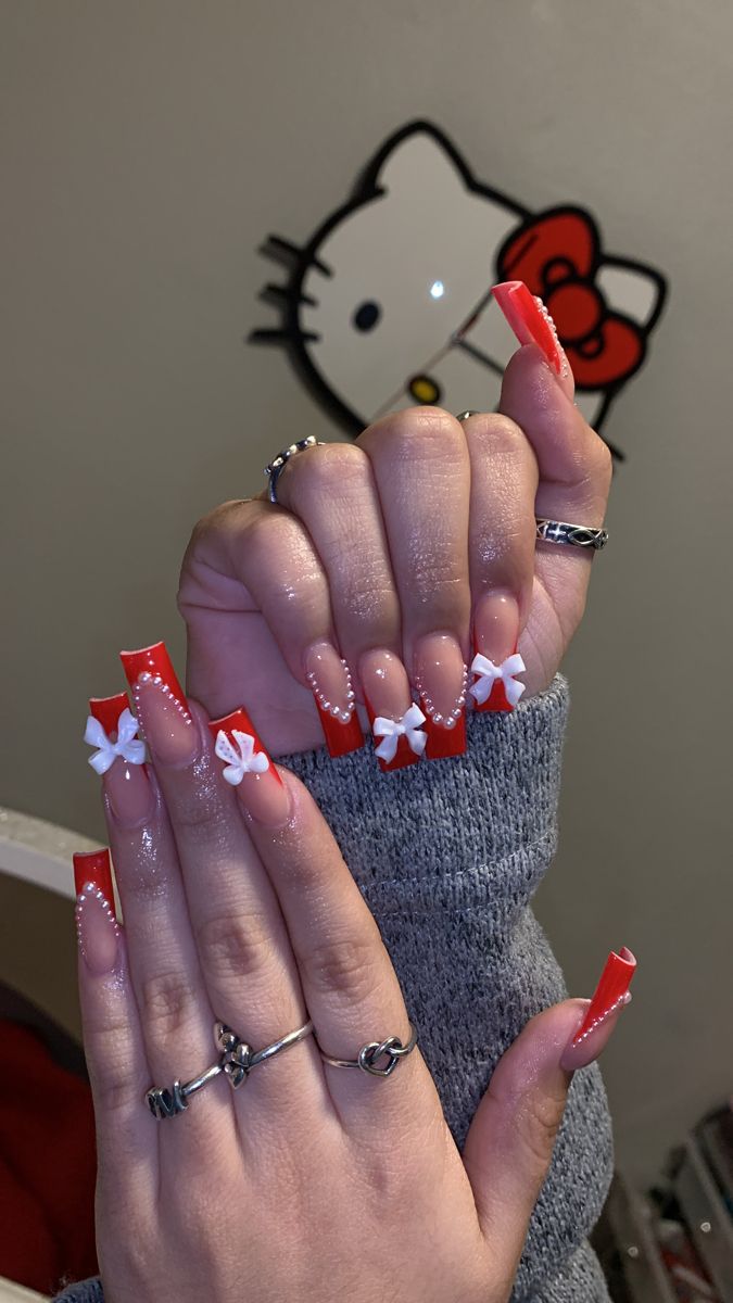 Elegant Festive Nail Design: Vibrant Red and Soft Pink Acrylics with Intricate Details, White Bows, and Pearl Accents.