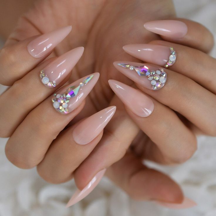 Elegant Almond-Shaped Nails with Nude Polish and Iridescent Rhinestone Designs for Sophisticated Glamour.