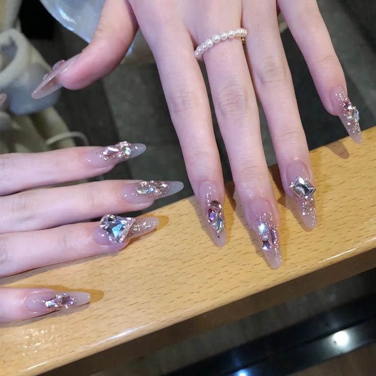 Chic Nude and Transparent Nail Design Accentuated by Glamorous Crystalline Embellishments.