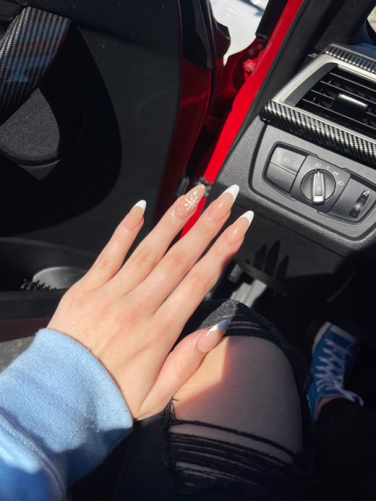 Elegant Long White-Tipped Nail Design with Subtle Accent in Modern Car Interior.