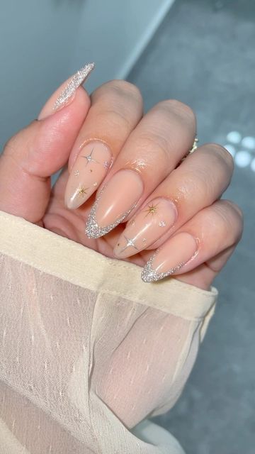 Celestial-Inspired Nail Design with Nude Base, Sparkling Silver Tips, and Gold Star Accents