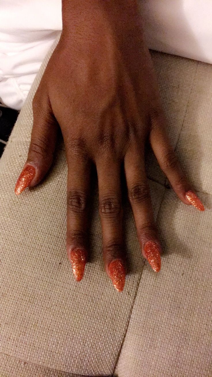 Vibrant Sparkling Orange Almond Nails: Elegant and Festive for Any Occasion.