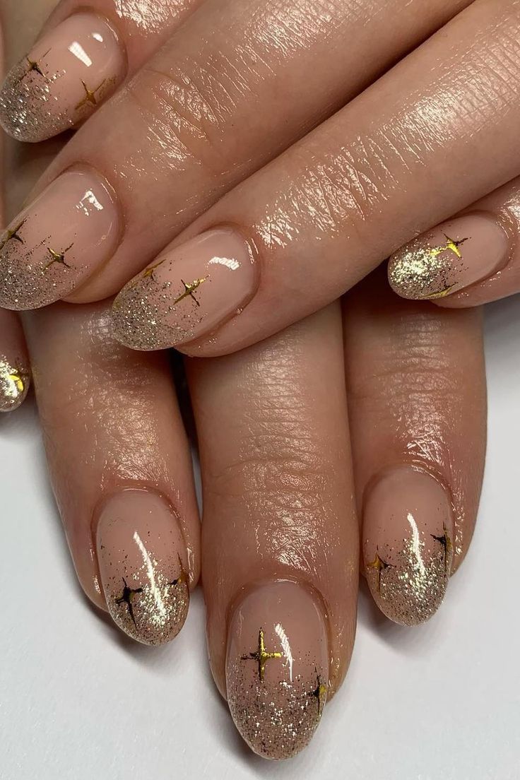 Sophisticated Nude and Gold Ombre Nail Design with Star Accents