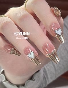 Elegant Chic Nail Design with Metallic Accents and Playful Heart Motifs.