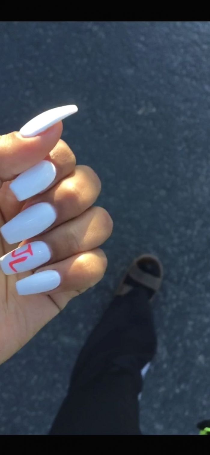 Elegant Long Squoval White Nails with Glossy Finish and Artful Accents for Every Occasion.