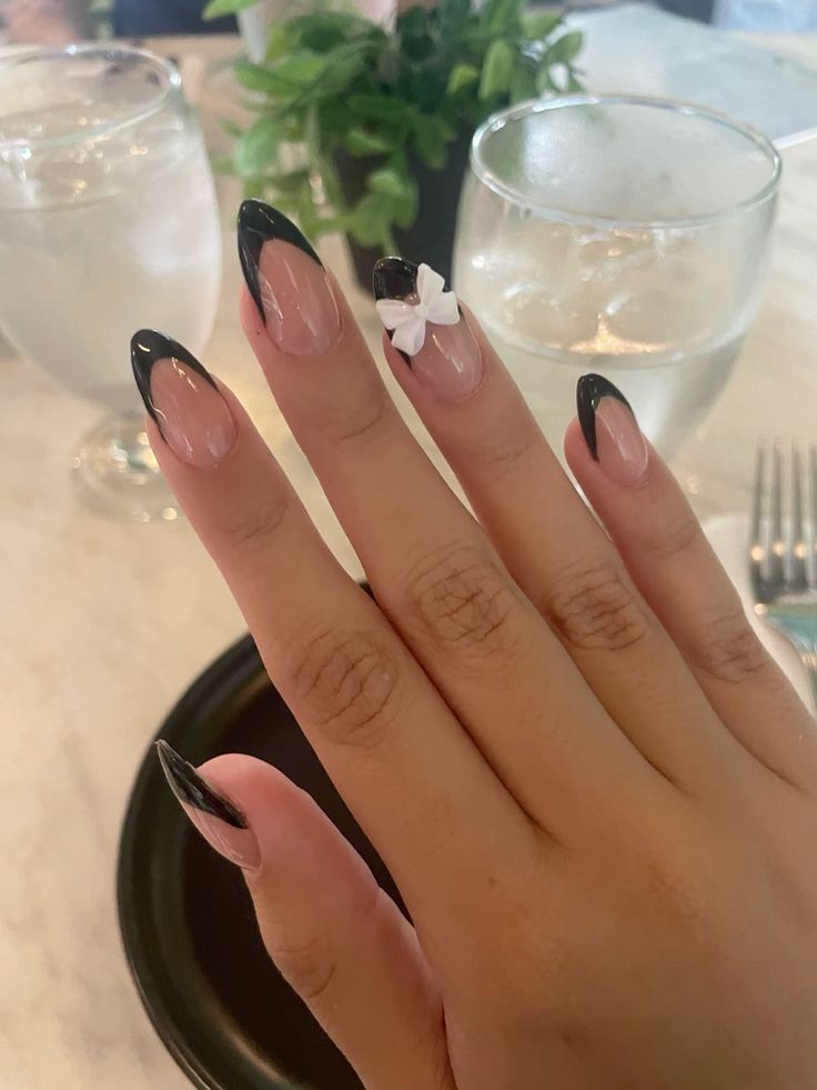 Chic French Tip Nail Design with Modern Black Tips and Delicate White Bow Accents.