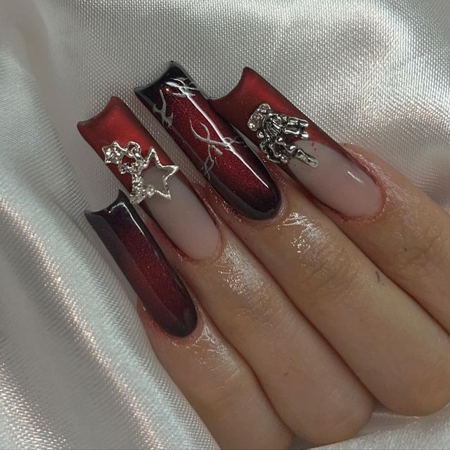 Stunning Gradient Nail Design: Bold Red and Black with Silver Accents and Intricate Star Details.