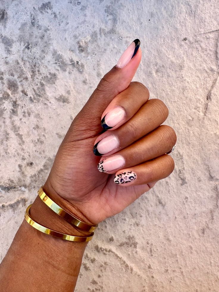 Chic Nail Design: Elegant Pink Base with Bold Black Tips and Playful Leopard Accent.