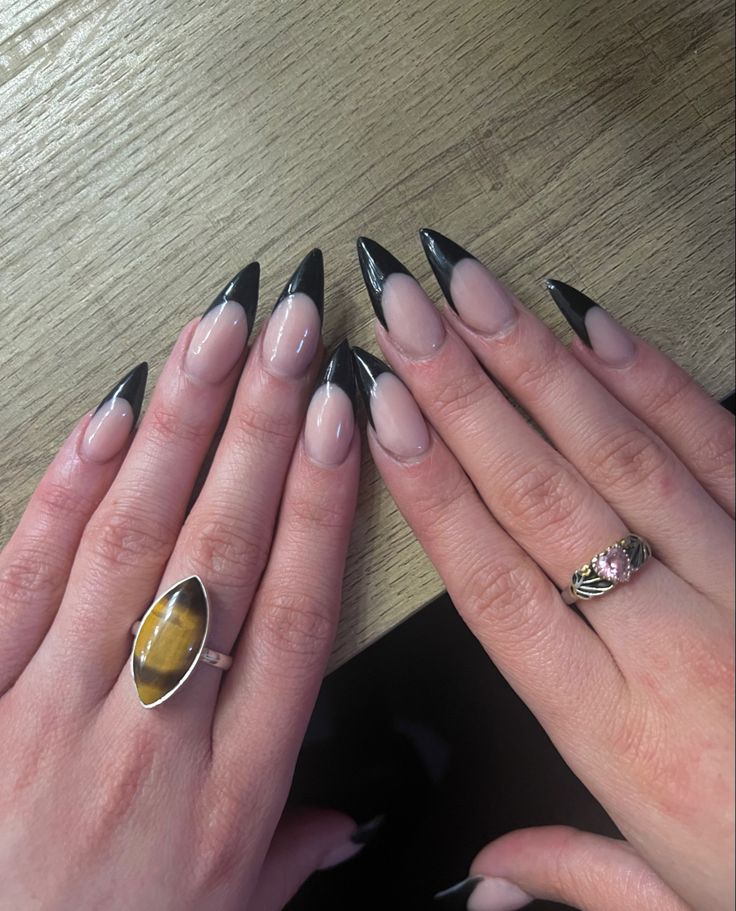 Chic French Tip Stiletto Nails: A Striking Nude and Black Elegance for Any Occasion.