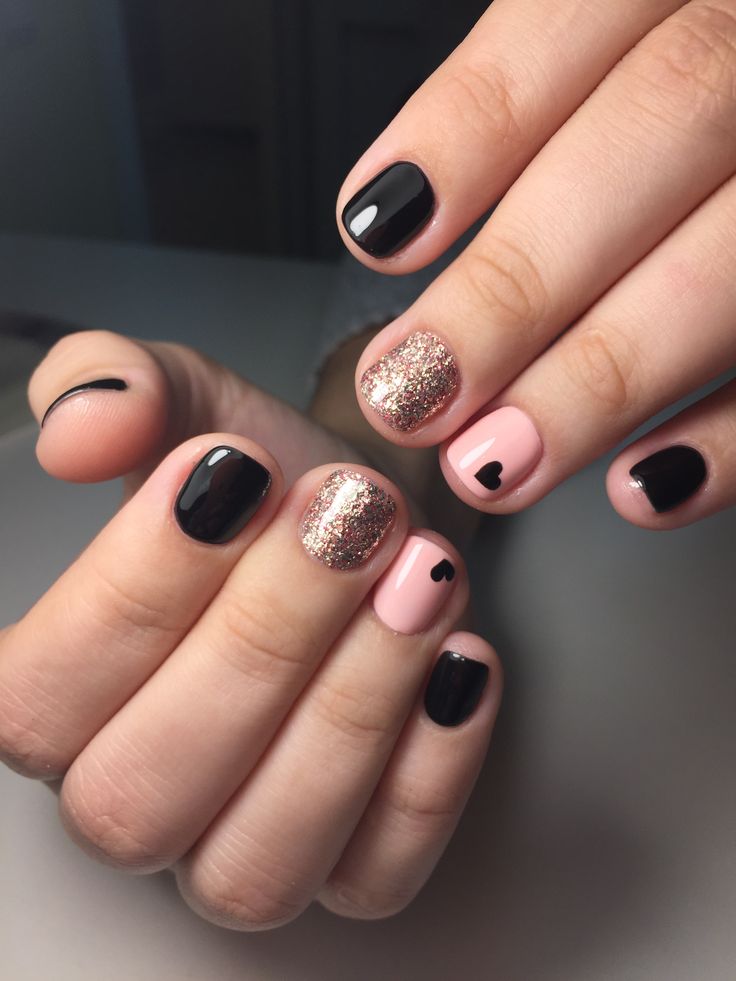 Chic Nail Design: Bold Black and Soft Pink with Glitter Accents and Heart Motifs.