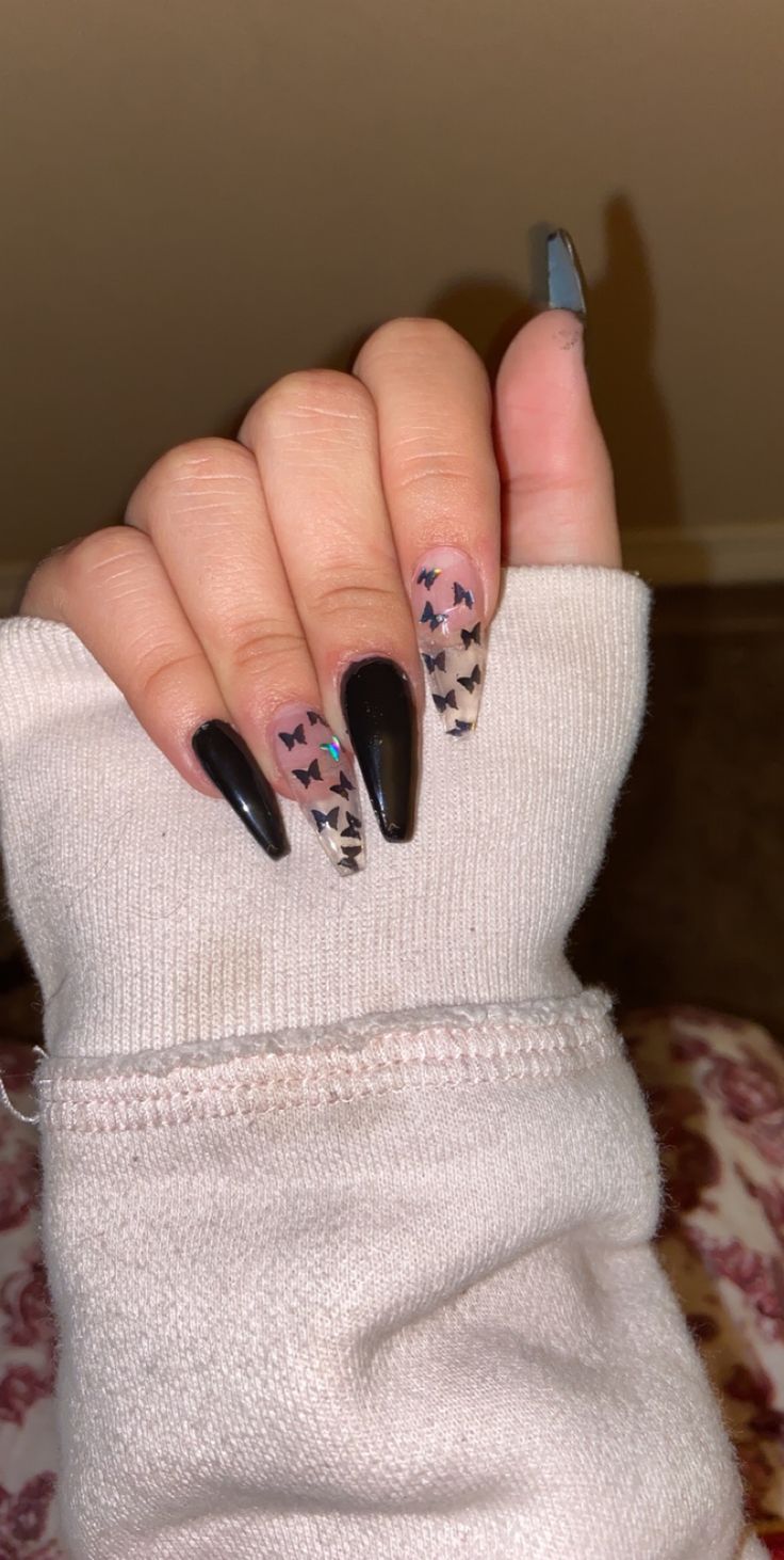 Chic Stiletto Nail Design: Black and Nude with Butterfly Patterns and Sparkle