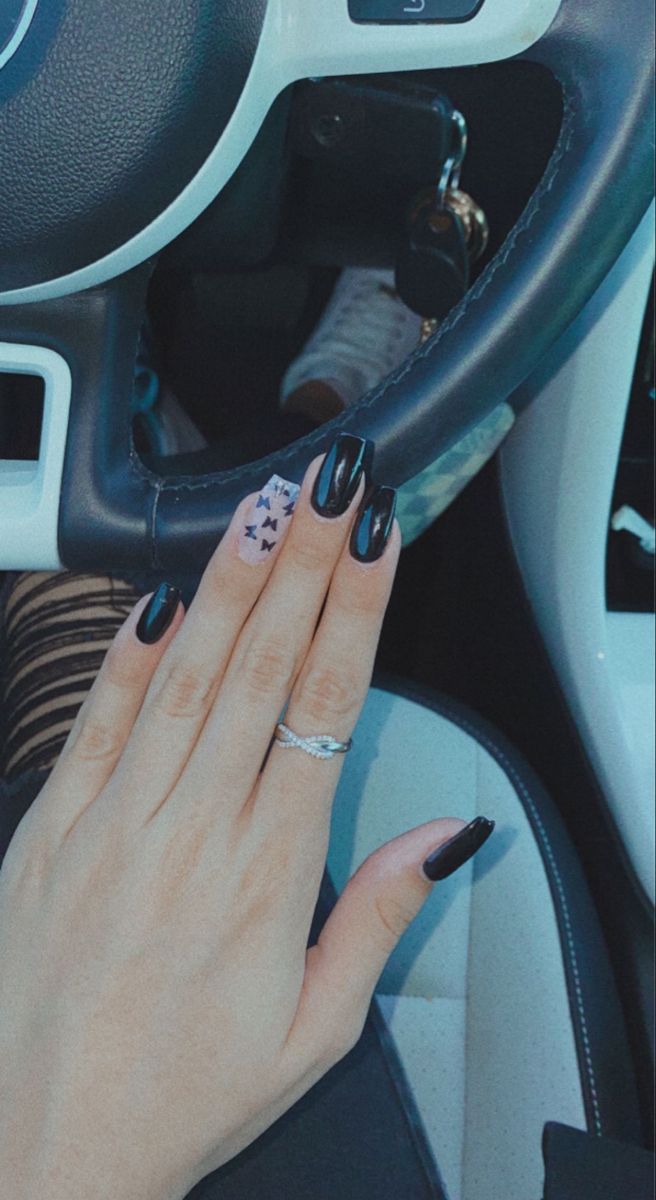 Stylish Black Manicure with Whimsical Butterfly Accent Nail.