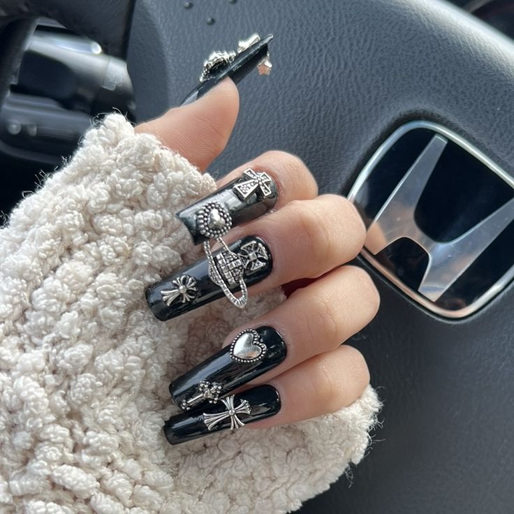 Striking Black Nails with Metallic Charms: Elegant Nail Design for Unique Style.