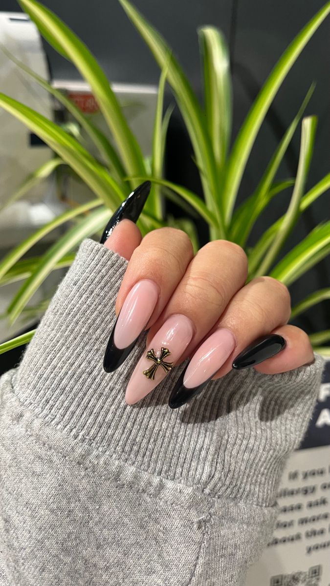 Elegant Nail Design: Nude Pink with Bold Black Tips and Gold Cross Embellishment