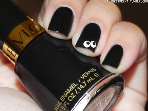 Playful Matte Black Nail Design with Cartoon Eyes Accents.