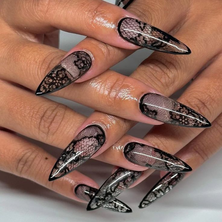 Elegant Stiletto Nails with Intricate Black Lace Design on Sheer Pink Base.