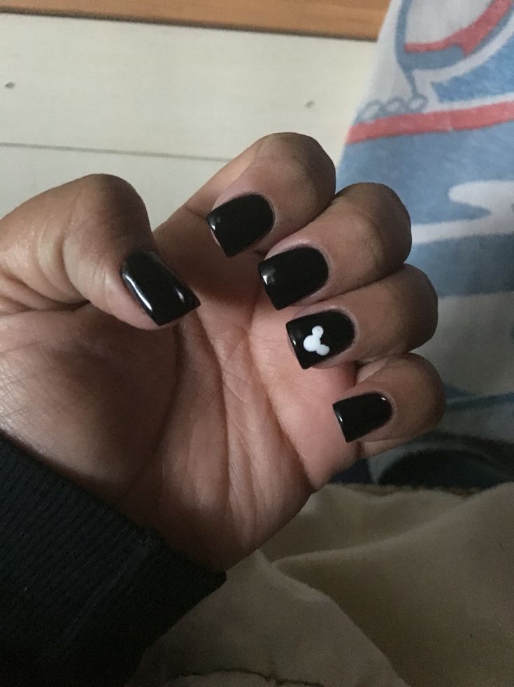 Chic Black Nail Design with Glossy Finish and Playful White Accent.