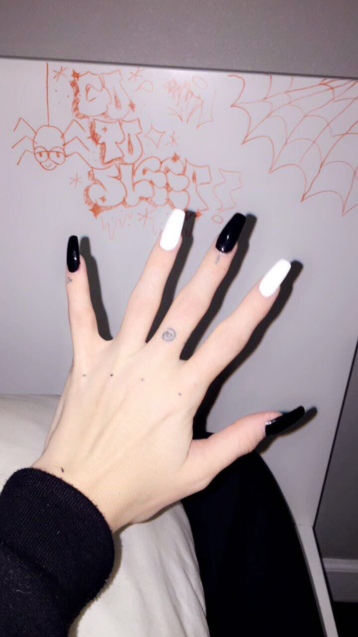 Edgy Black and White Almond-Shaped Nail Design with Unique Details.