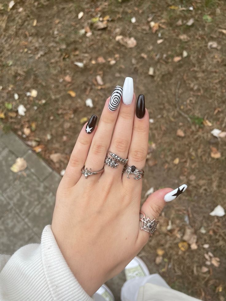 Striking Black, White, and Light Blue Nail Design with Bold Geometric Patterns and Silver Ring Accessories.