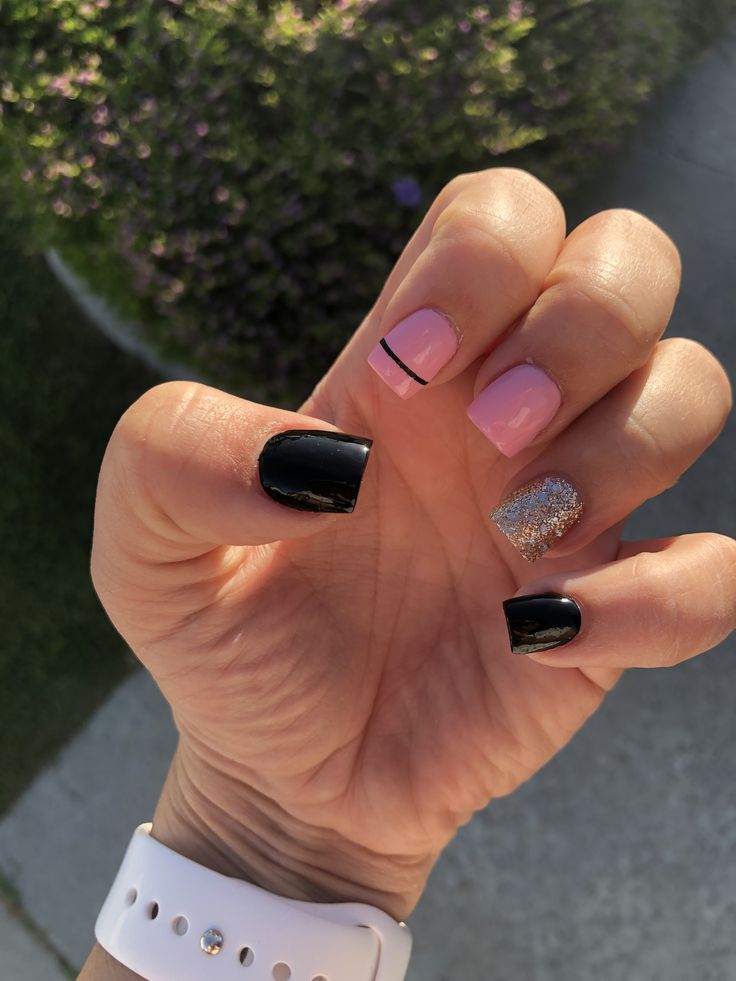 Trendy Playful Nail Design: Bold Black Base with Soft Pink, Delicate Lines, and Shimmering Silver Glitter Accent.