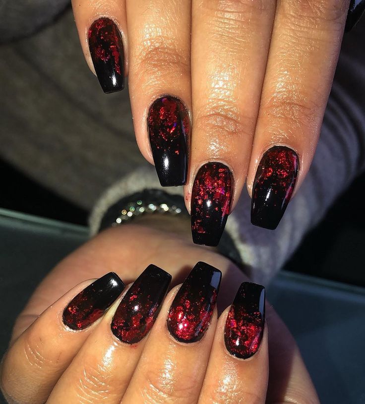 Bold Glossy Black Nails with Shimmering Red Accents for a Dramatic Statement.